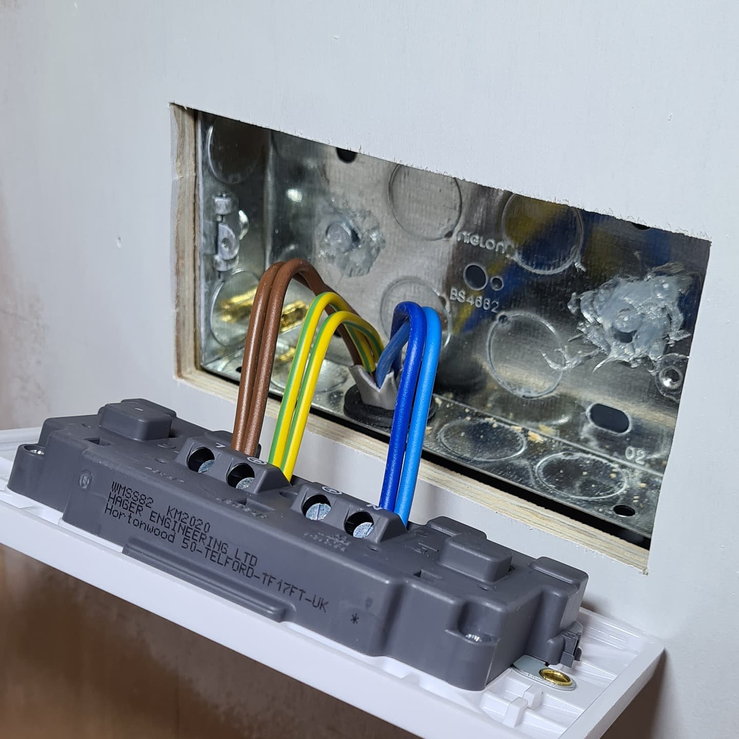 First-fix wiring into a metal back box — line, neutral and CPC terminated cleanly before the accessory goes on.